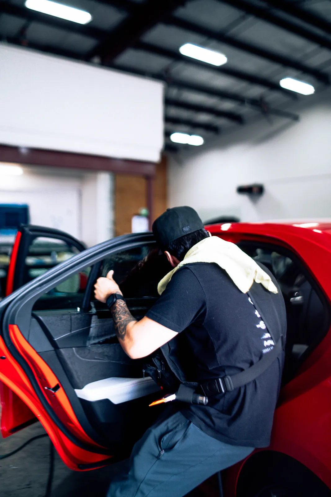 719 Auto Customs installer fitting window tint on a red sports car door